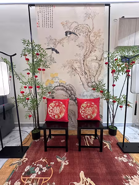 Chinese tea ceremony setup with ink painting backdrop, red dragon phoenix cushions, nandina trees, and red lanterns