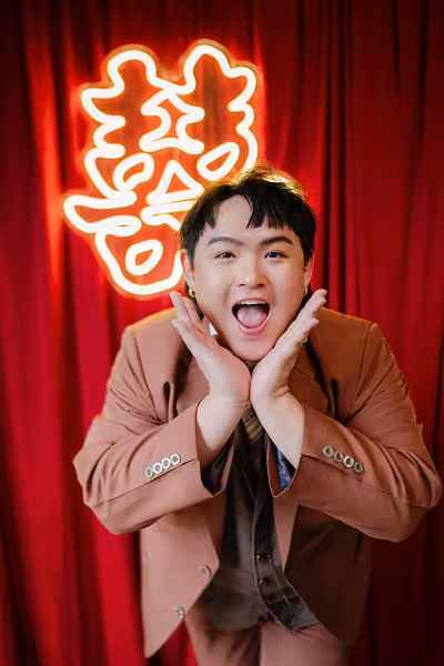 囍 Double Happiness LED neon light signage glowing warm white against a rich red pleated fabric backdrop