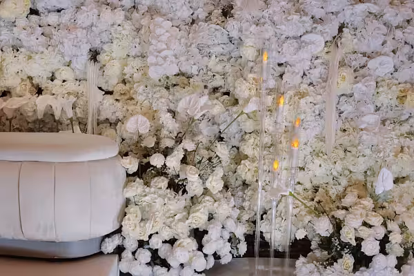 Elegant 6-Arm Acrylic Candelabra with glowing candles against a lush all-white floral wall backdrop