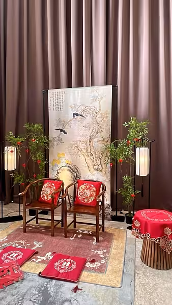 Chinese tea ceremony decor with ink painting backdrop, wooden chairs with dragon phoenix cushions, arch lantern floor lamps, and red carpet