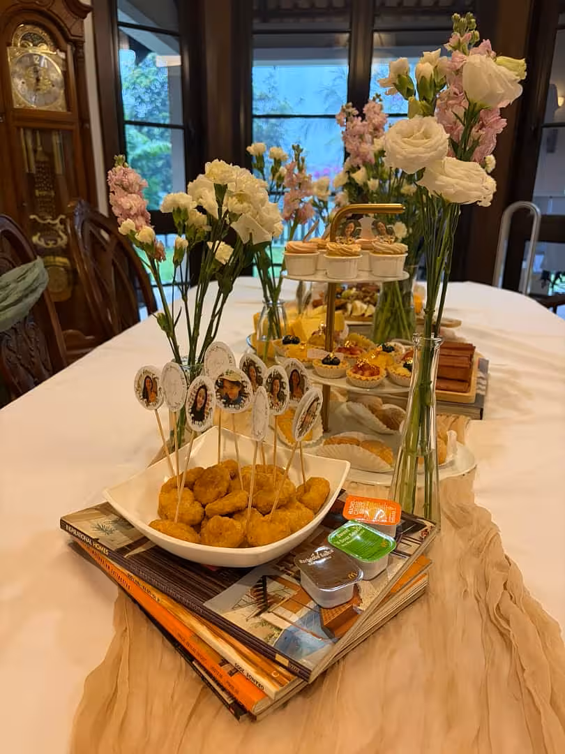 Cream crumpled table runner draped over a styled dessert table with white and pink floral arrangements in glass vases