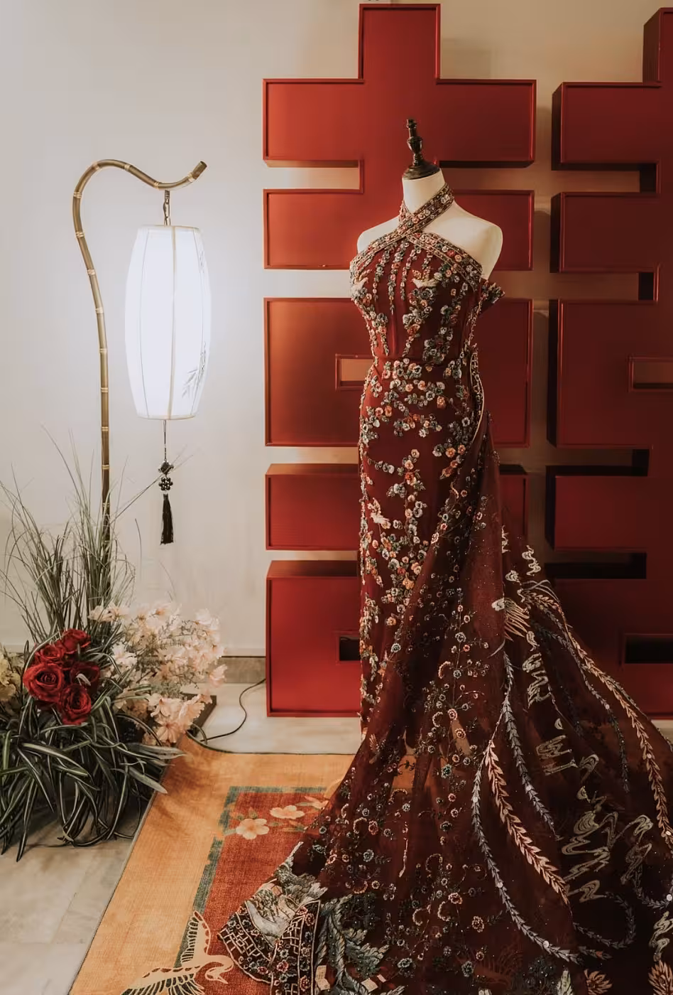 Deep red Chinese lattice backdrop with antique bamboo LED floor lamp, vibrant red floral carpet, and red artificial floor flowers