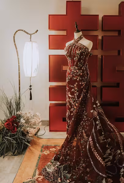 Deep red Chinese lattice backdrop with antique bamboo LED floor lamp, vibrant red floral carpet, and red artificial floor flowers