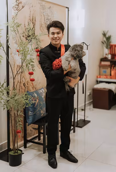 Ancient Chinese ink painting hanging cloth backdrop with black arch stand, red velvet lanterns on artificial nandina plant, and royal blue embroidered satin cushion on black wooden chair