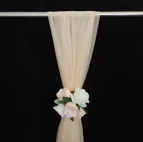 Champagne netted nylon fabric draped over a silver rod, cinched with a cluster of blush and white artificial roses