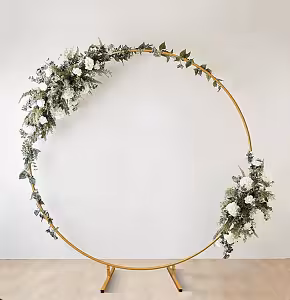 Gold Round Stand styled with white roses, lush greenery and eucalyptus garland cascading across the upper-left arc and lower-right side