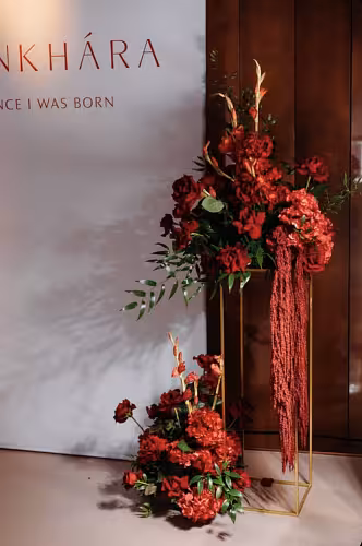 Gold Iron Decorative Event Stand 80 cm styled with a dramatic cascade of deep red roses, hydrangeas, and trailing amaranthus beside a backdrop