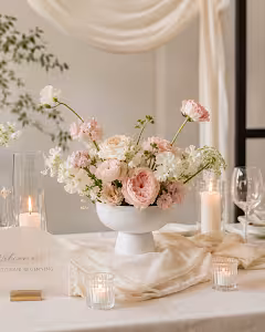 White Pedestal Bowl Vase styled as a wedding centrepiece with blush roses and white blooms, surrounded by candles on a draped table