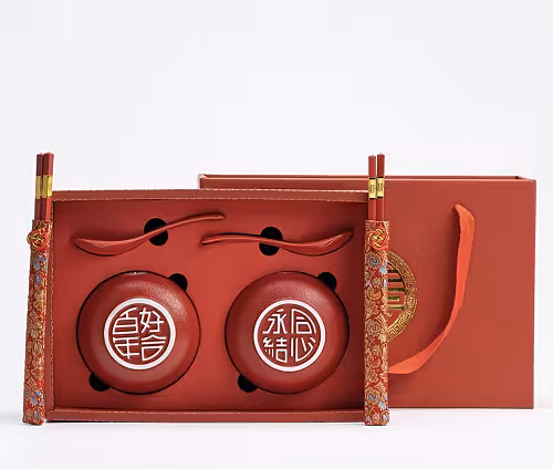 Oriental Red Lantern Bowl Set with two red ceramic bowls bearing Chinese characters, red spoons, gold-tipped chopsticks, and a red gift box