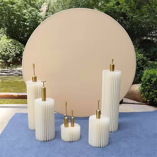 Cream Round Elastic Cloth Arch Stand backdrop paired with five varied-height cream pleated pillar pedestals with gold tops on a blue carpet